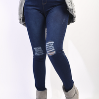 Dark blue high-waisted skinny jeggings with distressed knee rips and light fading