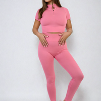 Pink half-zip crop top and high-waist leggings set, ribbed stretch knit, fitted two-piece.