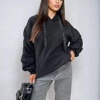 Black oversized hoodie with drawstring hood, front pouch pocket, and ruched sleeves