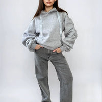 Light gray oversized hoodie with drawstring hood, front pouch pocket, and ruched sleeves