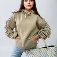 Oat/beige oversized hoodie with drawstring hood, front pouch pocket, and ruched sleeves