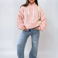 Oversized pink hoodie with ruched sleeves, pouch pocket, and drawstring hood