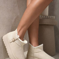 Cream suede ankle boots with faux fur lining, side buckle strap, and thick tread platform sole.
