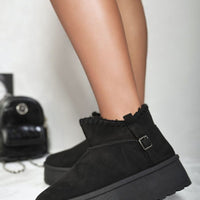Black suede ankle boots with faux fur lining, side buckle strap, and chunky platform sole.