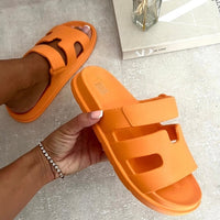 Orange slide sandals with geometric cutout straps, slip-on style