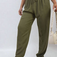 Olive green high-waist drawstring trousers with side pockets and relaxed tapered legs