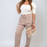 Taupe/beige high-waist drawstring trousers with side pockets and tapered straight legs