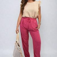 Fuchsia high-waist drawstring trousers with side pockets and gathered waist.