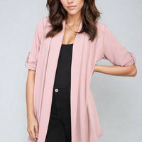 Blush pink open-front cardigan with short sleeves and draped front over black outfit