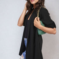 Black open-front cardigan with roll-up sleeves, loose drape over denim