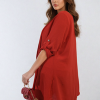 Red open-front cardigan with short roll sleeves and buttoned shoulder detail