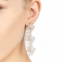 Silver triple drop flower earrings on ear with three textured jasmine blooms