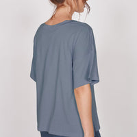 Oversized blue v-neck t-shirt, back view with short sleeves and draped hem