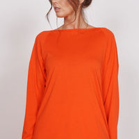 Orange long-sleeve training top with crew neck, smooth lightweight fabric
