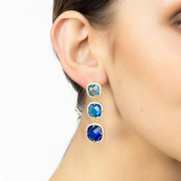 Blue and gold drop earrings shown on ear with three faceted stone tiers