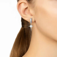 Silver starburst drop earring on model's ear