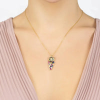 Owl rainbow pendant necklace in gold, worn with a pink dress