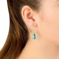 Blue topaz teardrop drop earrings on ear, gold-tone hook