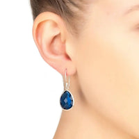 Petite drop earrings with blue faceted teardrop stone and silver hook on ear