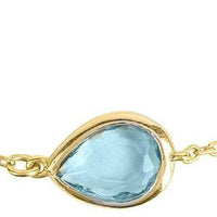 Gold bezel teardrop bracelet centerpiece with blue topaz stone