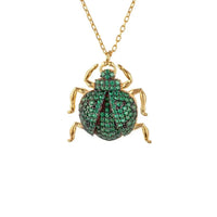 Gold-tone scarab pendant necklace with green gem detailing and chain