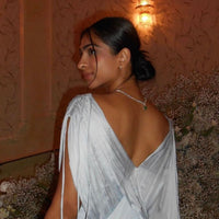 Silver oval gemstone tennis necklace with emerald stone on model's back