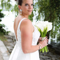 Bride wearing silver textured flower drop earrings with white pearl dangles