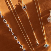Gold-tone evil eye necklaces with blue eye pendants and crystal accents