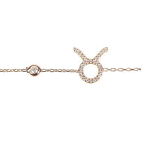 Gold-tone Taurus charm bracelet close-up with clasp ring and star sign pendant