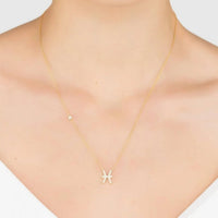 Gold Pisces zodiac pendant necklace on neckline, thin chain