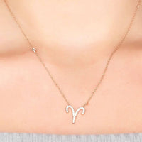 Gold-tone Aries zodiac pendant necklace with rhinestone details on a fine chain