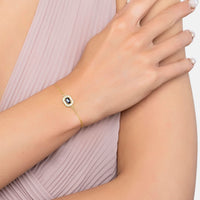 Gold bracelet with blue sapphire oval gemstone on wrist