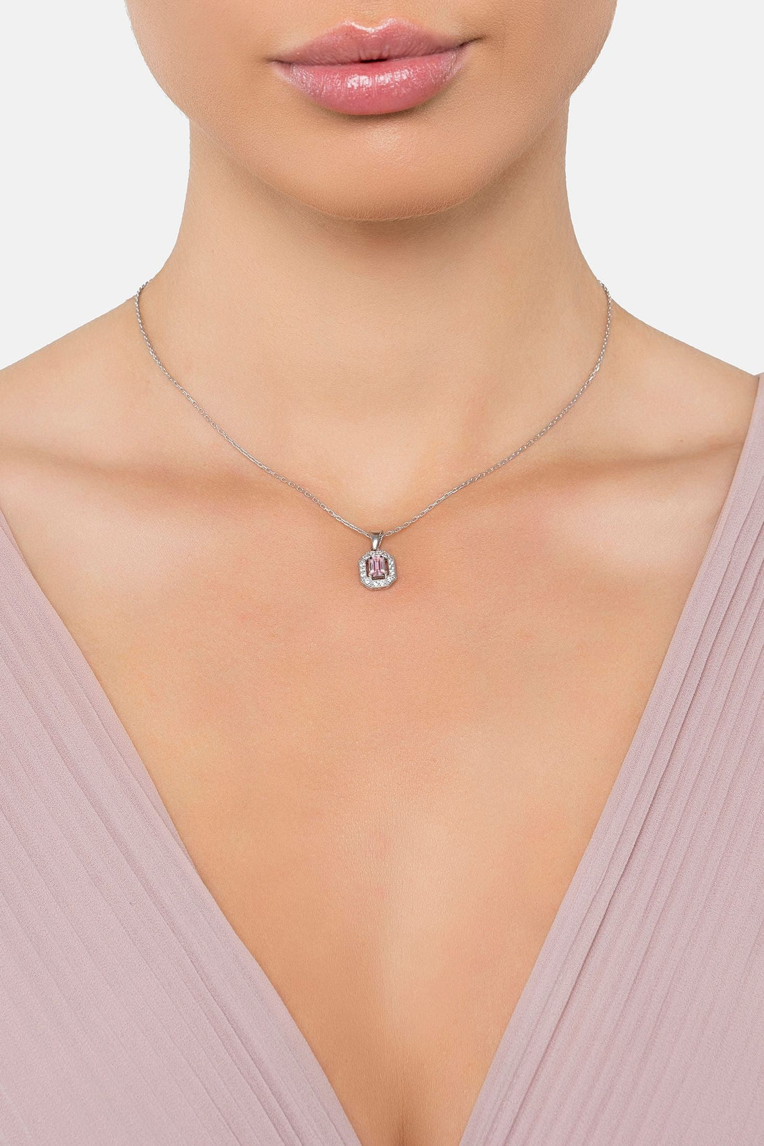 Silver pendant necklace with small round halo and pink gemstone centerpiece