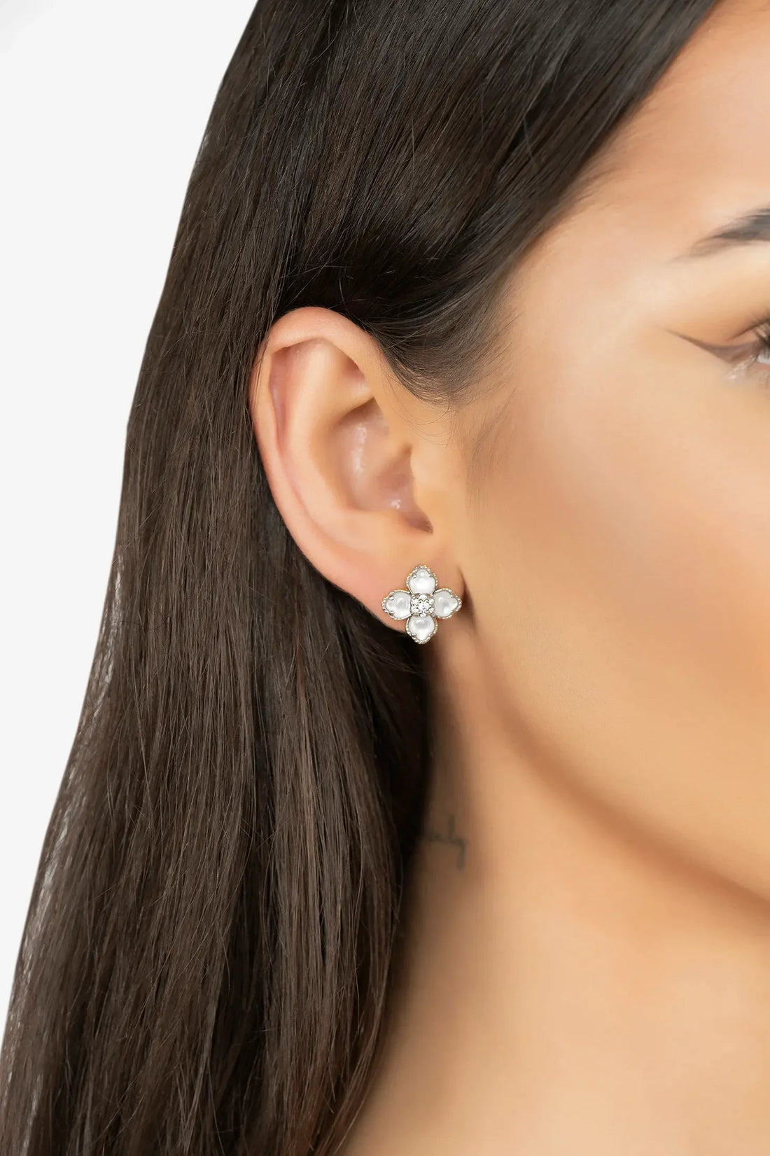 Clover flower stud earrings on ear, silver-tone mother-of-pearl petals with crystal center