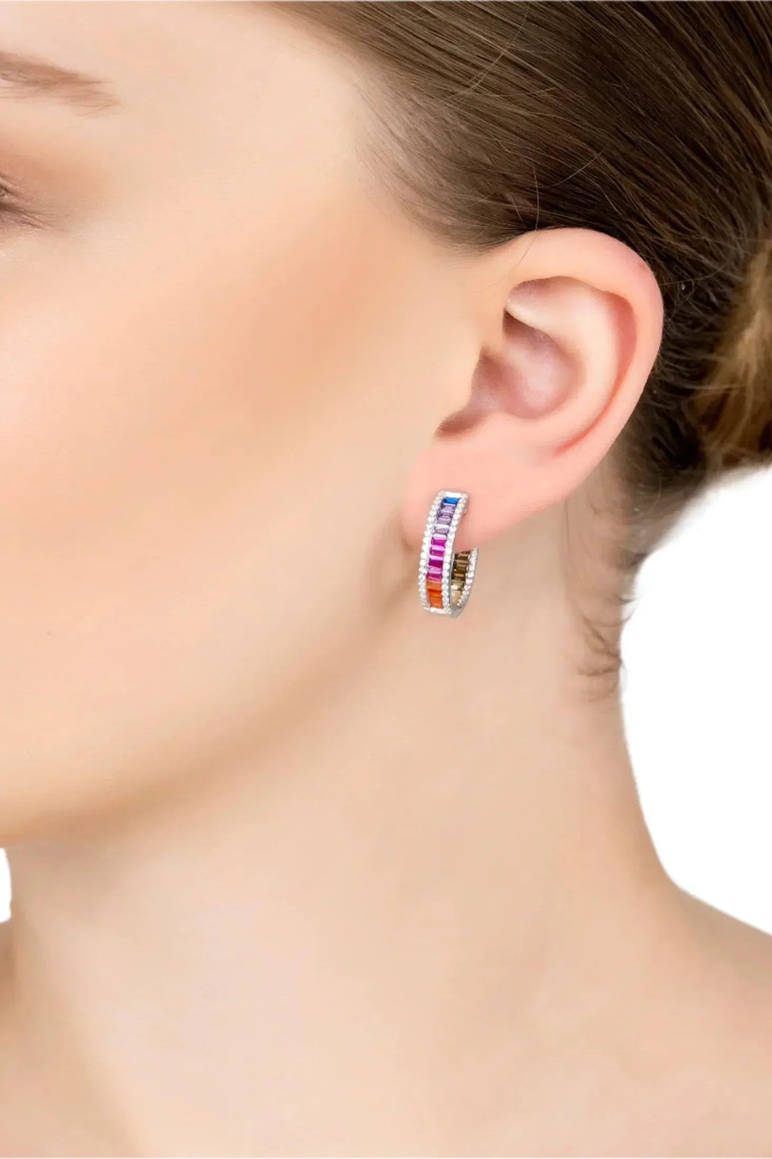 Silver rainbow baguette hoop earrings worn on ear with multicolor gemstone band