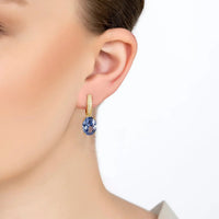 Alexandra gold oval drop earring with tanzanite stone, shown worn on ear