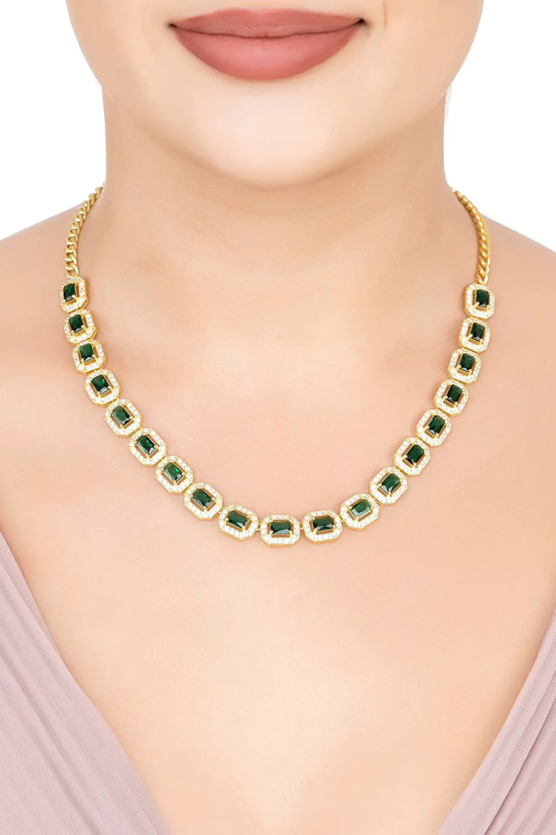 Gold-tone emerald-green gemstone necklace worn at the collar