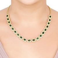 Gold-tone emerald-green gemstone necklace worn at the collar