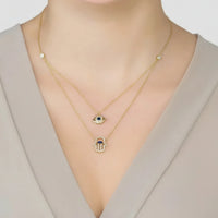 Gold layered evil eye and hamsa pendant necklace, two delicate chain layers
