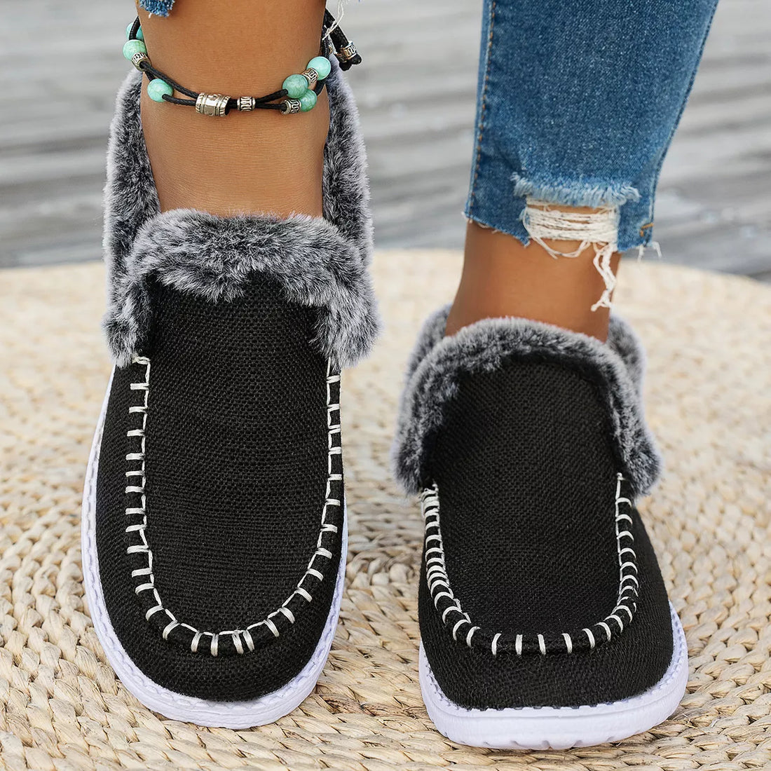 Black faux fur lined round toe slip-on shoes with fuzzy collar and white stitching