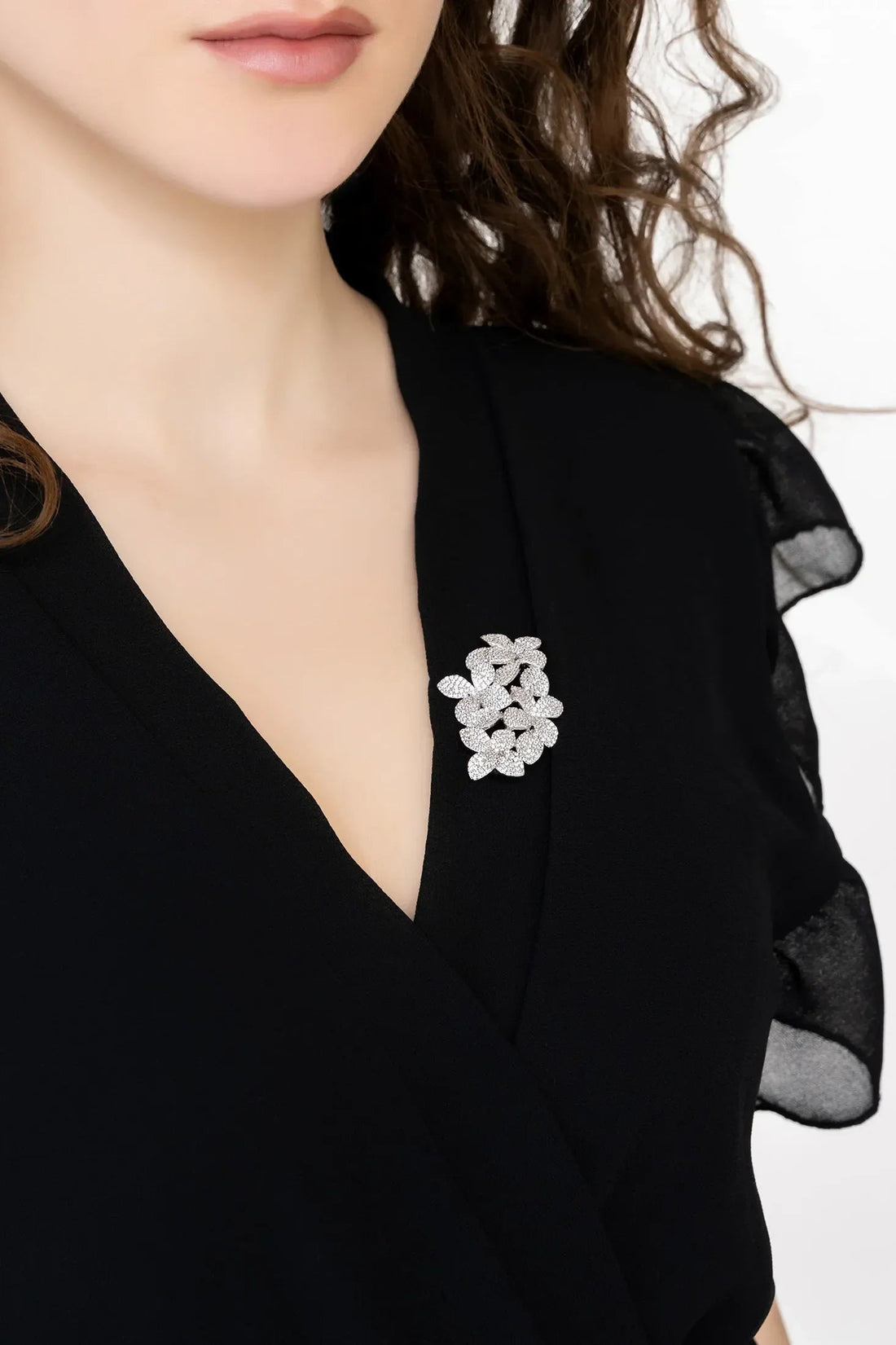 Silver flower brooch on black V-neck top