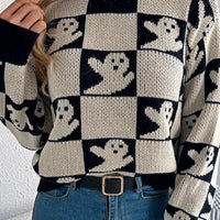 Black and cream checkerboard knit Halloween sweater with ghost face graphics, long sleeves