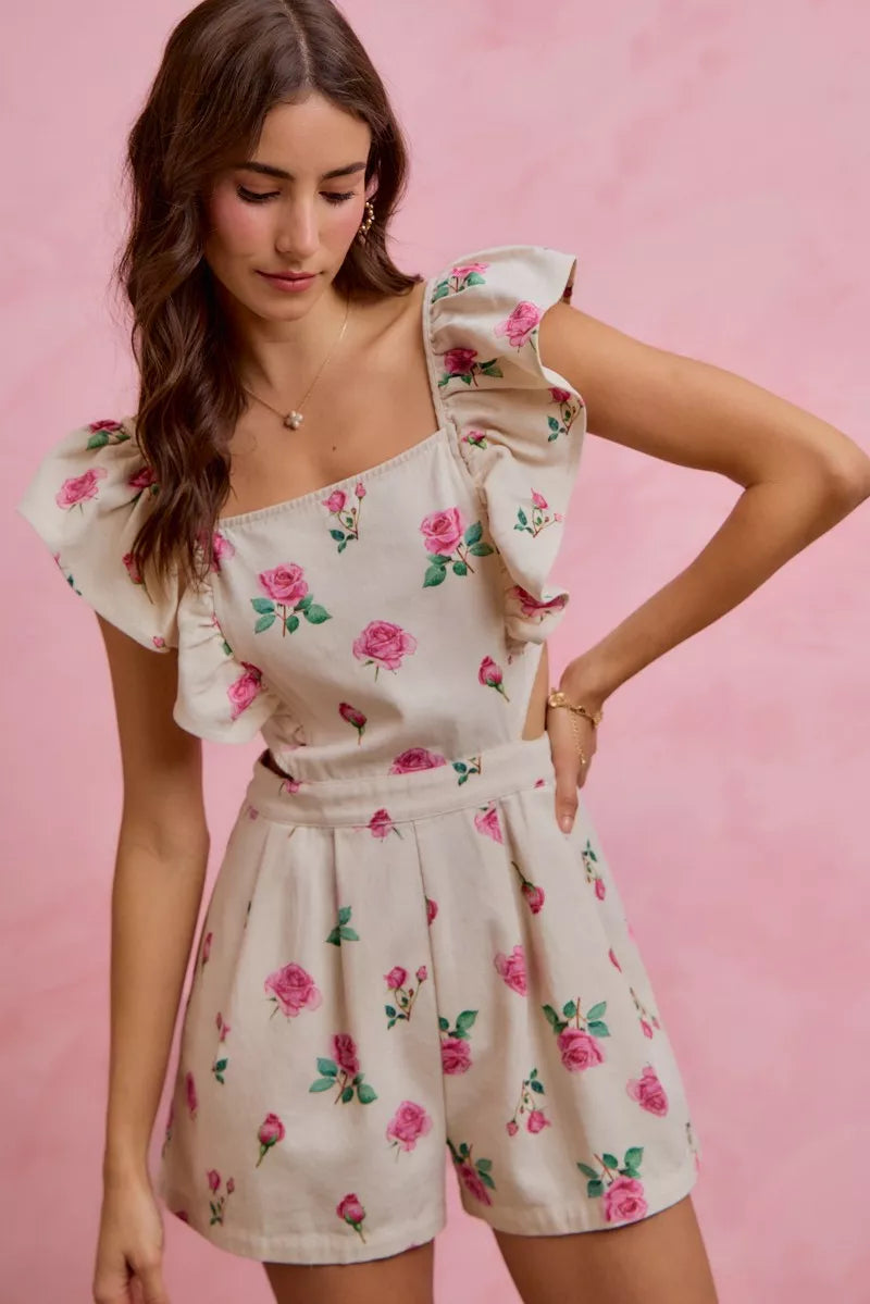 Ivory floral romper with cut-out waist and ruffled sleeves, pink rose print