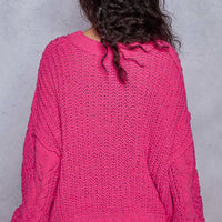 Back view of fuchsia cable-knit cropped V-neck sweater with long sleeves and ribbed hem