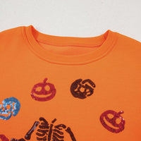 Orange crewneck sweatshirt close-up: sequin critter icons near ribbed neckline