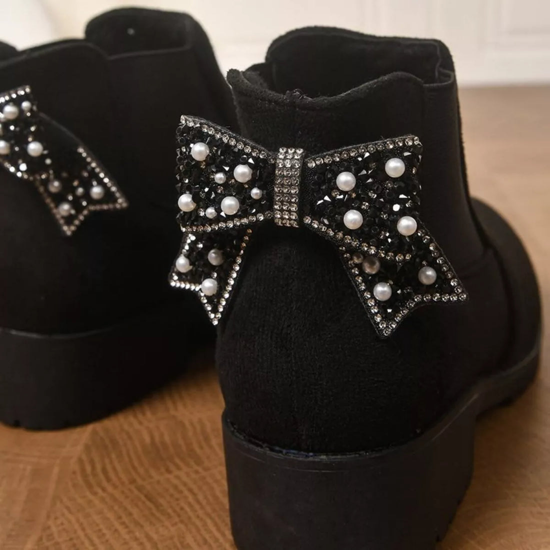 Black suede ankle boots with round toe, block heel, rhinestone bow with pearl accents