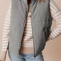 Gray corduroy stand-neck zipped puffer vest with pockets and full front zipper.