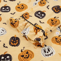 Gold Halloween pumpkin print shorts close-up, elastic waistband and ruffled trim