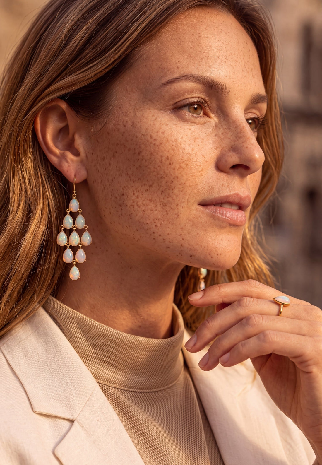 Close-up of silver opal teardrop chandelier earrings with dangling drops and hook backs.