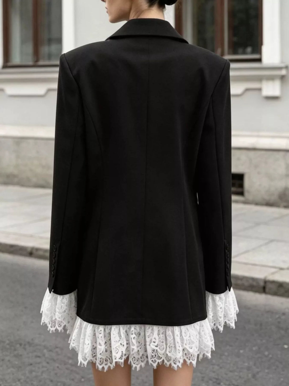 Back view of black one-button blazer with lace-trim hem